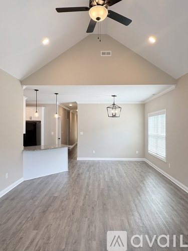 A spacious room with a ceiling fan and lighting fixtures.