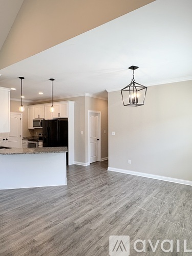 A modern kitchen with a bar area and pendant lights.