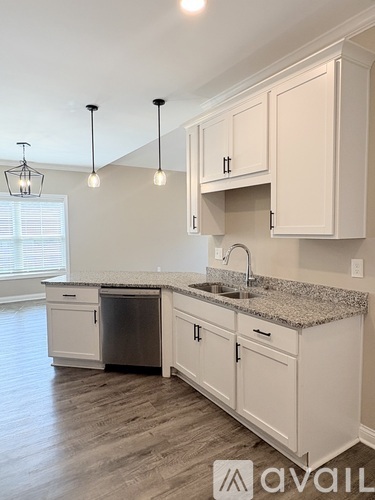 A kitchen with white cabinets and a granite countertop.