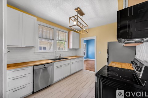 A kitchen with white cabinets and a black stove top oven.