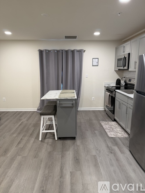 A kitchen with a table and a refrigerator.