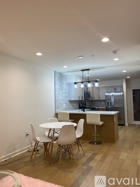 A kitchen with a white table and chairs.