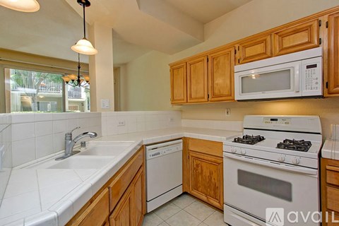 A kitchen with wooden cabinets and white appliances.