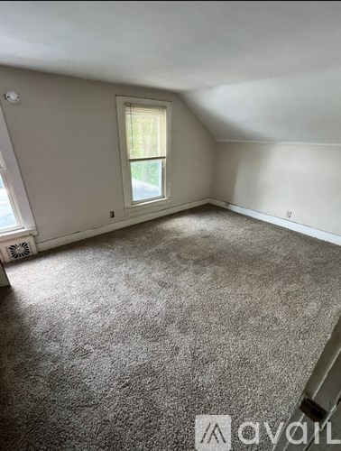 A room with a carpeted floor and a window.