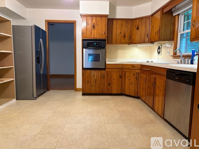 A kitchen with wooden cabinets and a tile floor.