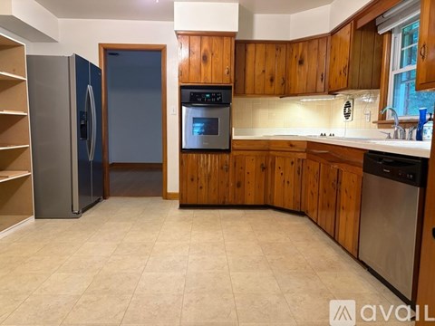A kitchen with wooden cabinets and a tile floor.