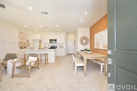 A modern kitchen with white cabinets and a dining table with chairs.
