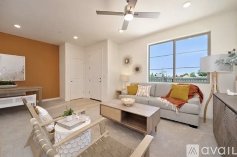 A living room with a white couch, a wooden chair, and a coffee table.