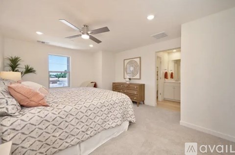 A bedroom with a large bed and a ceiling fan.