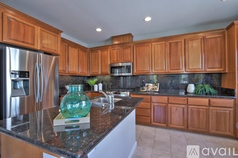 A kitchen with wooden cabinets and a granite countertop.