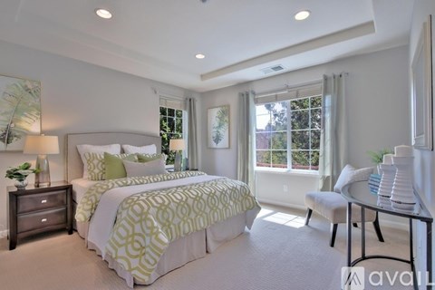 A bedroom with a large bed and a window with a view of trees.