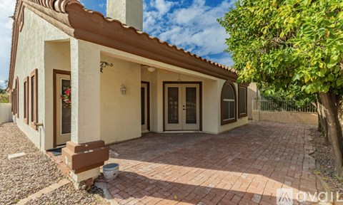 A house with a red tile roof and a brick walkway in front.