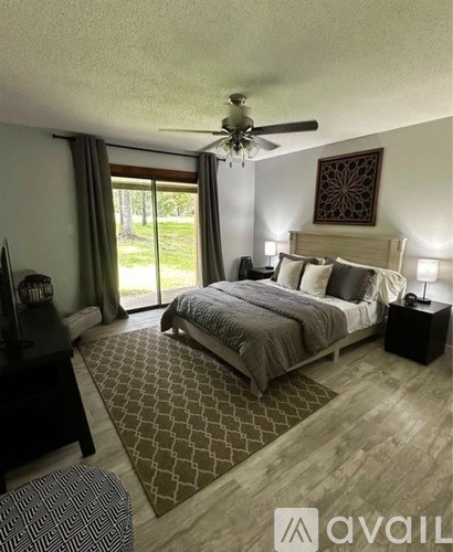 A bedroom with a large bed and a ceiling fan.
