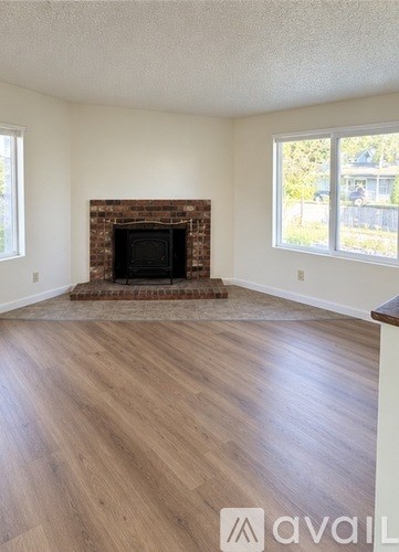 A living room with a fireplace and wood flooring.