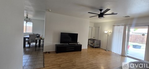 A living room with a television and a sliding glass door.