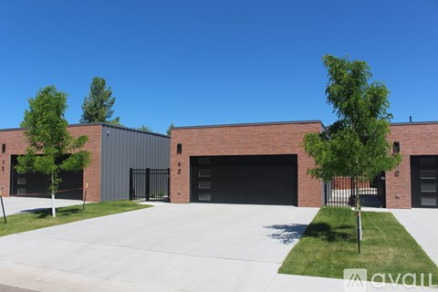 A modern building with a large garage door and a tree in front.