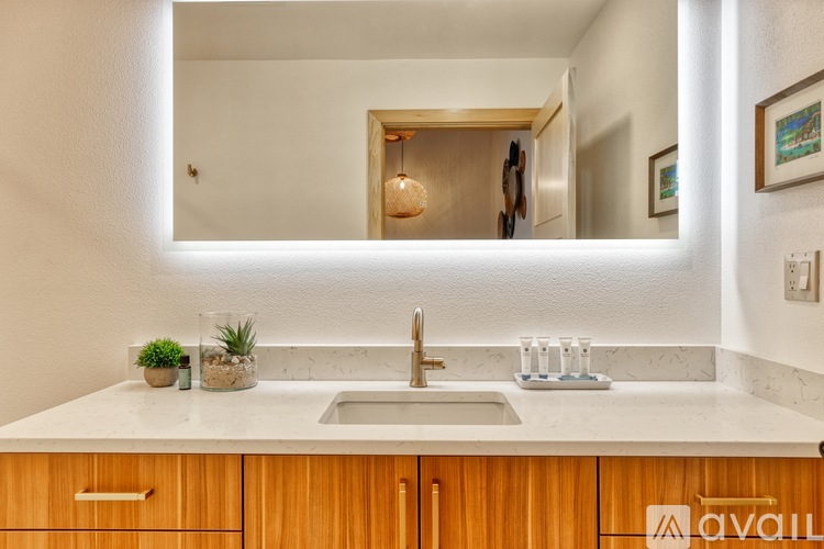 A modern kitchen with a wooden cabinet and a marble countertop.