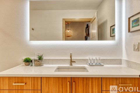 A modern kitchen with a wooden cabinet and a marble countertop.