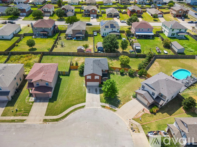 A bird's eye view of a neighborhood with houses and a pool.