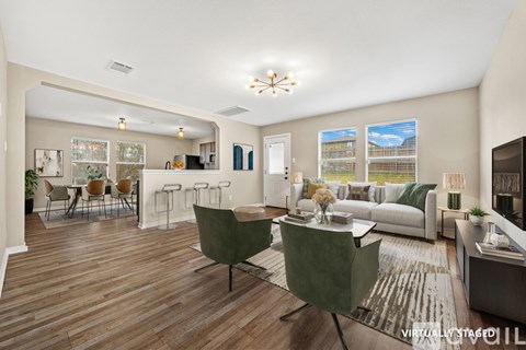 A living room with a green chair and a white couch.