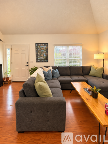 A living room with a grey couch and a wooden table.