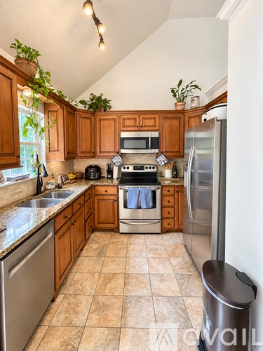 A kitchen with wooden cabinets and a tiled floor.