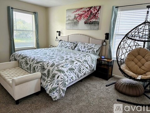 A bedroom with a large bed and a hanging chair.
