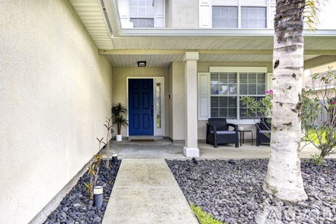 A house with a blue door and a white wall.