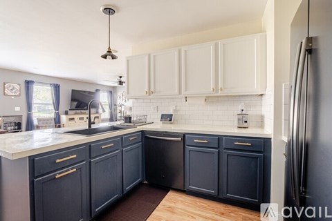 A kitchen with dark blue cabinets and white countertops.