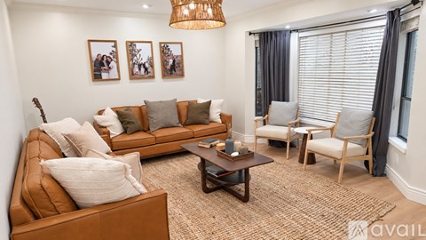 A living room with a brown couch, a coffee table, and a guitar.