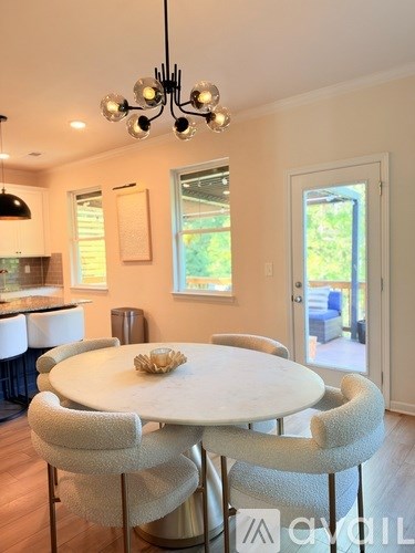 A modern dining room with a round table and chairs.