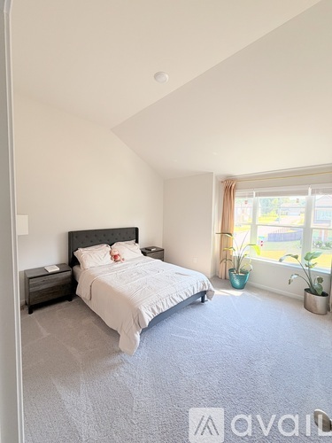 A bedroom with a large bed and a window with a view of the outside.