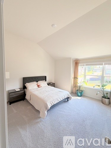 A bedroom with a large bed and a window with a view of the outside.