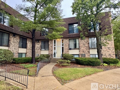 A brick apartment building with a white door and windows.