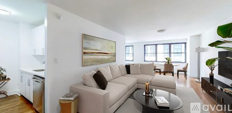 A living room with a couch, a coffee table, and a painting on the wall.