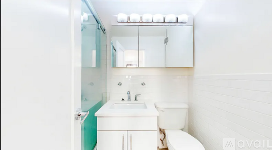 A white bathroom with a toilet, sink, and mirror.