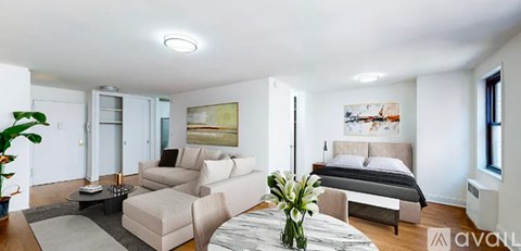 A bedroom with a bed, couch, and coffee table.