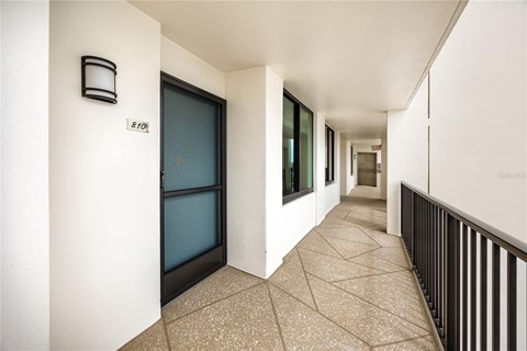 A hallway with a black railing and a door with a star design on it.