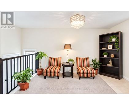 A living room with a striped couch and a lamp.