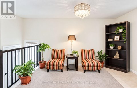 A living room with a striped couch and a lamp.