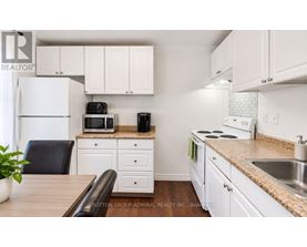 A kitchen with white cabinets and appliances.