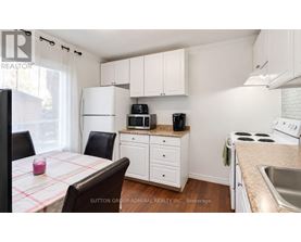 A kitchen with white cabinets and a checkered tablecloth.