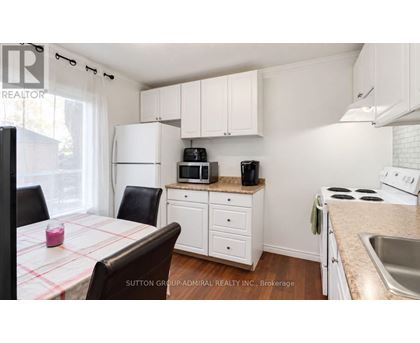 A kitchen with white cabinets and a checkered tablecloth.