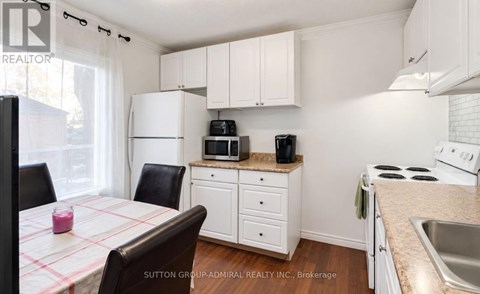 A kitchen with white cabinets and a checkered tablecloth.