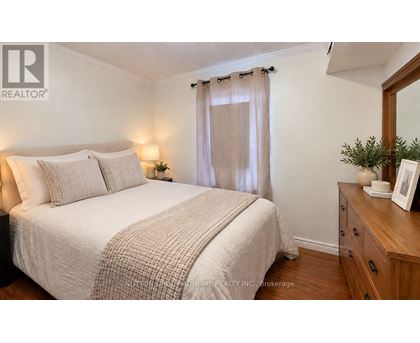 A bedroom with a bed, nightstand, and a mirror.