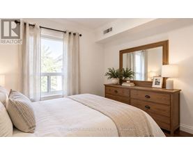 A bedroom with a bed, dresser, and window.