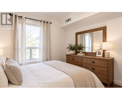 A bedroom with a bed, dresser, and window.