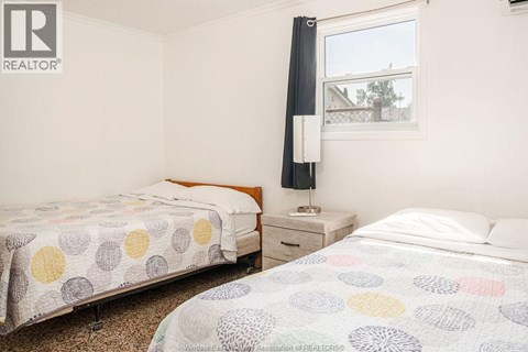A bedroom with two beds and a window.