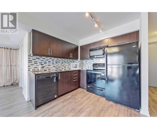 A modern kitchen with wooden cabinets and stainless steel appliances.