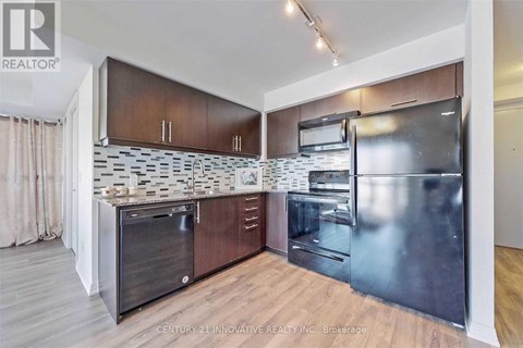 A modern kitchen with wooden cabinets and stainless steel appliances.